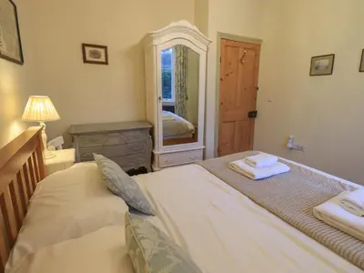 a bedroom with a bed and a dresser and a mirror at Fairy Glen in Ambleside