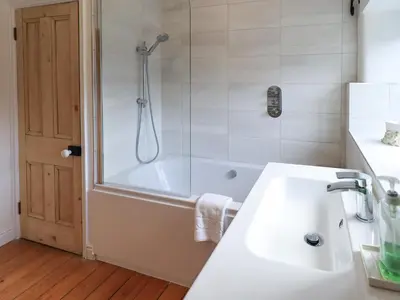 a bathroom with a shower and a sink and a tub at Daisy Cottage in Grasmere