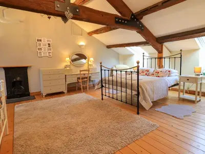 a bedroom with a bed and a desk and a fireplace at Daisy Cottage in Grasmere