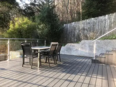 a table and chairs sitting on a deck at Dancing Beck Cottage in Keswick