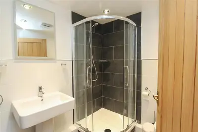 a bathroom with a shower and a sink at Elterwater Lodge in Little Langdale
