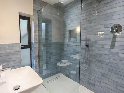 a bathroom with a glass shower and a sink at Gillside in Keswick