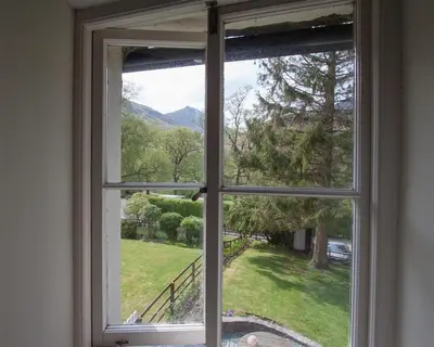 an open window with a view of a yard at Grisedale Cottage in Keswick