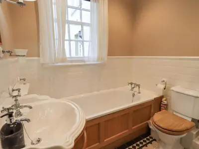 a bathroom with a tub and a toilet and a sink at Grisedale View in Keswick