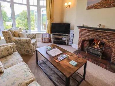 a living room with a fireplace and a coffee table at Sandburne Cottage in Keswick