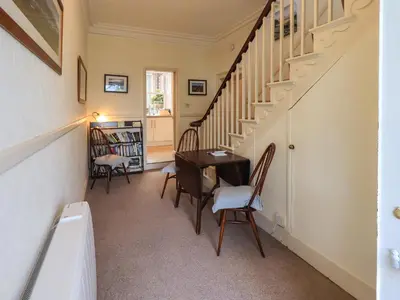 a hallway with a desk and chairs in a house at Sandburne Cottage in Keswick