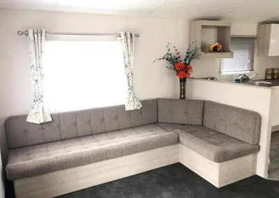 a couch in a living room with a window at Burrowhead Holiday Village in Isle of Whithorn