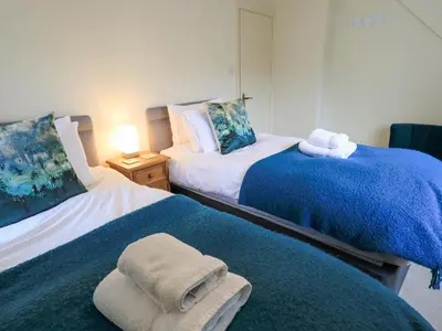 a bedroom with two beds with towels on them at Holme Rigg in Keswick
