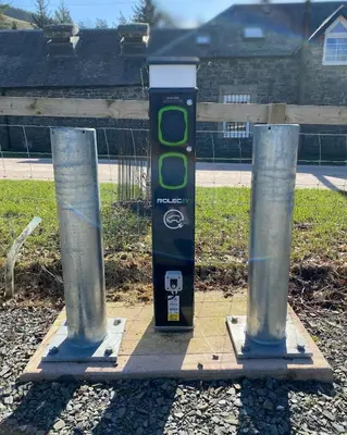 a parking meter sitting between two posts on a street at Lategillan Cottage in Polmood