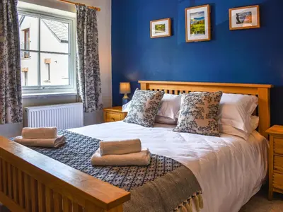 a bedroom with a large bed with blue walls at The Old Workshop in Keswick