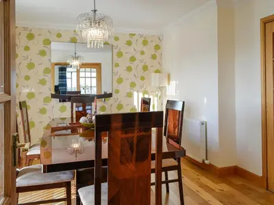 a dining room with a table and a mirror at Ashgrove in Mainsriddle