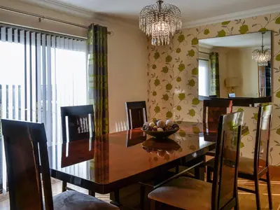 a dining room with a table and a chandelier at Ashgrove in Mainsriddle