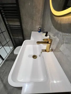 a white sink in a bathroom with two toilets at Modern Town-Centre Apartment in Dumfries