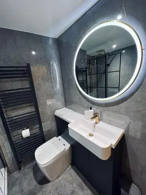 a bathroom with a white sink and a mirror at Modern Town-Centre Apartment in Dumfries