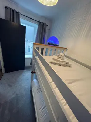 a bedroom with a bed with a blue helmet on it at Modern Town-Centre Apartment in Dumfries