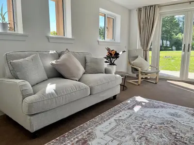 a living room with a couch and a chair at The Coorie in Bargrennan
