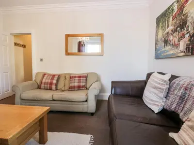 a living room with a couch and a table at Carlton House Apartment 1 in Keswick