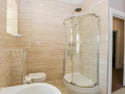 a bathroom with a toilet and a glass shower at Carlton House Apartment 1 in Keswick