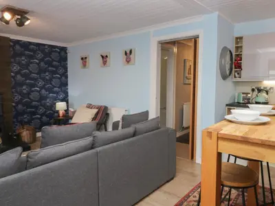 a living room with a couch and a dining room at The Chalet in Egremont