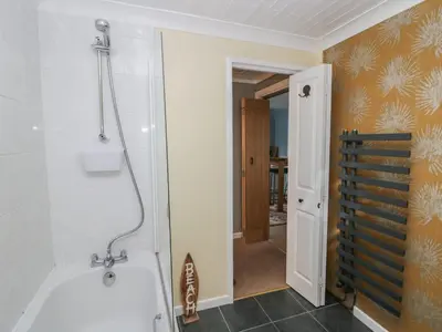 a bathroom with a shower and a tub at The Chalet in Egremont