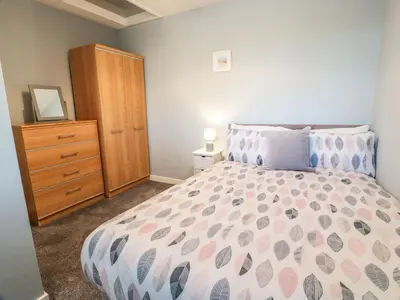 a bedroom with a large bed and a dresser at Rothiemay in Girvan