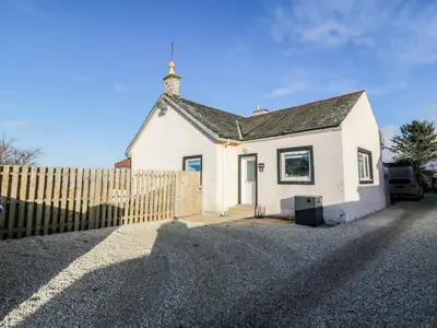 a white house with a fence in front of it at Rothiemay in Girvan