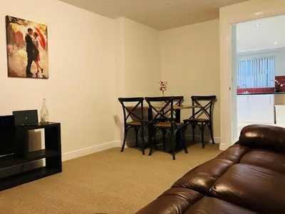 a living room with a couch and a table and chairs at Cosy home near hospital in Carlisle