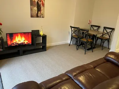 a living room with a couch and a fireplace at Cosy home near hospital in Carlisle
