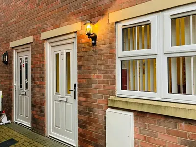 a brick building with white doors and windows at Cosy home near hospital in Carlisle