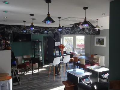 a dining room with tables and chairs and lights at Ryans Retreat, Bowness on Solway perfect for a break when walking Hadrians Wall with a hot tub in Bowness-on-Solway