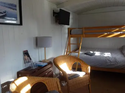 a bedroom with a bunk bed and a chair at Sians Retreat, Bowness on Solway, perfect stop over when walking Hadrians Wall with hot tub in Bowness-on-Solway