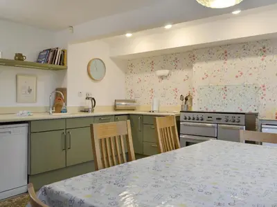 a kitchen with green cabinets and a table with chairs at The Retreat in Sunderland