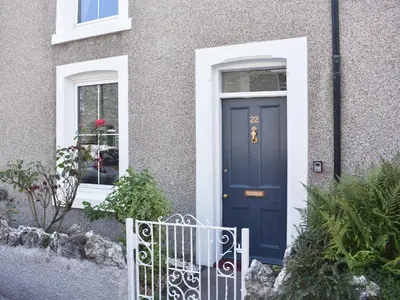 a blue door on a house with a fence at Long Rose in Keswick