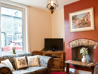 a living room with a couch and a tv at Long Rose in Keswick