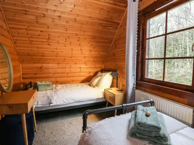 a bedroom with a bed in a log cabin at Moyle Lodge in Dalbeattie