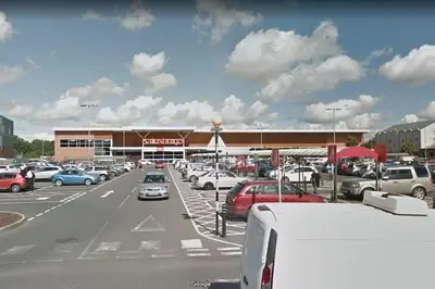 a parking lot with cars parked in front of a store at Luxury House Near City Center Hospital &Superstore in Carlisle