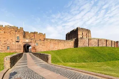 a castle on a hill with a pathway in front of it at Luxury House Near City Center Hospital &Superstore in Carlisle