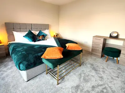 a bedroom with a bed and a chair and a desk at Grove House in Egremont