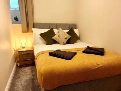 a bedroom with a bed with two towels on it at Grove House in Egremont