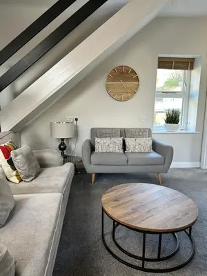 a living room with two couches and a table at 1 The Croft in Cockermouth