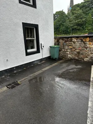 a building with a trash can next to a window at 1 The Croft in Cockermouth