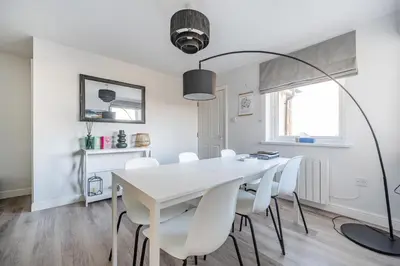 a white dining room with a white table and white chairs at Normsy Place Seaside Serenity Breath Taking Views in St Bees