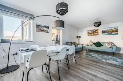 a dining room and living room with a white table and chairs at Normsy Place Seaside Serenity Breath Taking Views in St Bees