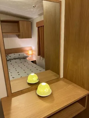 a reflection of a bedroom with a bed in a mirror at Turnberry Holiday Home in Turnberry