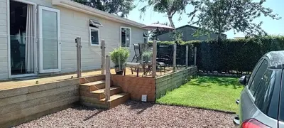 a backyard with a wooden deck with a table at 24 The Zen Den Cumbria in High Hesket