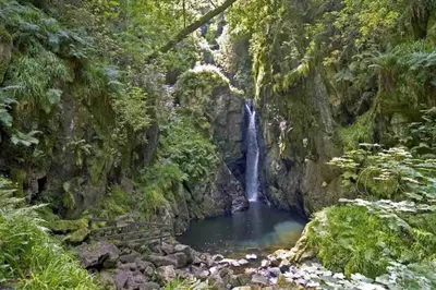 a waterfall in the middle of a canyon at Teapot Cottage in Ennerdale - Hot tub Pizza Oven Log Burner in Cleator