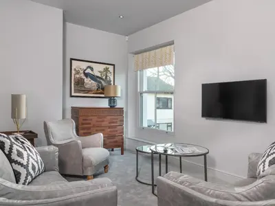 a living room with a tv and chairs and a table at Apartment 2 Blencathra in Keswick