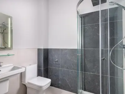 a bathroom with a shower and a toilet and a sink at Apartment 2 Blencathra in Keswick