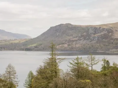 a view of a lake with trees and mountains at Apartment 2 Blencathra in Keswick