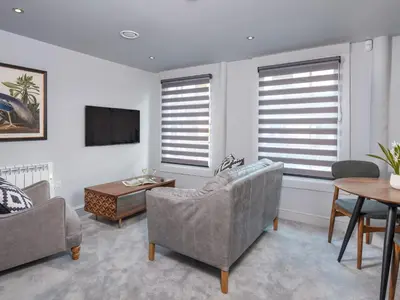 a living room with a couch and a table andwindows at Apartment 3 Helvellyn in Keswick